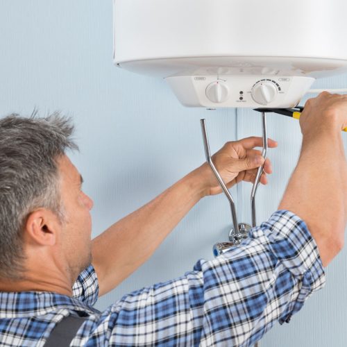 man repairing the water heater